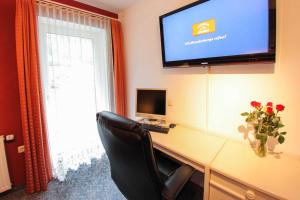 a room with a desk with a computer and a television at Appartement Gimpl in Fusch an der Glocknerstraße