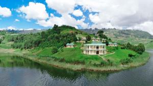 a large house on an island in the water at Nyamunyonyi Tourism Resort in Kabale