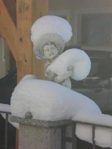 uma estátua de uma rapariga coberta de neve em Appartements Agnes em Fulpmes