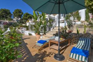 - une terrasse avec 2 chaises et un parasol dans l'établissement Casa Basta, à Moraira