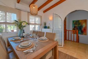 une salle à manger avec une table, des assiettes et des verres à vin dans l'établissement Casa Basta, à Moraira