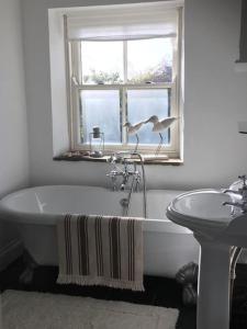 baño con bañera y ventana en Sanctuary Cottage at Blacko en Barrowford