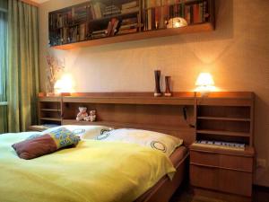 a bedroom with a bed with a shelf above it at Ferienwohnung Angelika in Bad Schallerbach