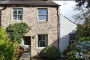 a stone house with a garden in front of it at Sanctuary Cottage at Blacko in Barrowford