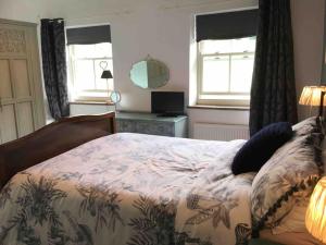 um quarto com uma cama e duas janelas em Sanctuary Cottage at Blacko em Barrowford