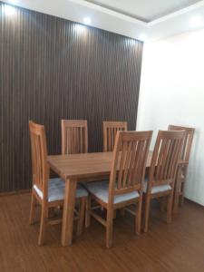 une table en bois avec quatre chaises, une table, une table et des chaises dans l'établissement Very secure apartment Bole Addis Enyi Real Estate, à Addis-Abeba