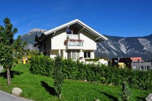 a house on a hill with mountains in the background at Ferienwohnung Wilhelm in Sautens