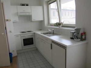 a white kitchen with a sink and a window at Gartenapartment nah beim Zentrum und ruhig in Vienna