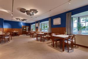 a dining room with tables and chairs and blue walls at Hotel Am Steendamm in Oyten