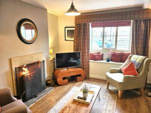 a living room with a television and a fireplace at 3 Bed in Helmsley 82891 in Helmsley