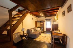 a living room with a staircase and a couch at Quintal De Alem Do Ribeiro-Turismo Rural in Lousã