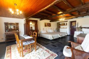 a bedroom with two beds and a table and chairs at Quintal De Alem Do Ribeiro-Turismo Rural in Lousã