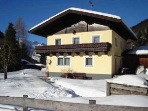 a house with snow on the ground in front of it at Ferienwohnung Jirkal in Sankt Martin bei Lofer