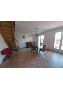 a living room with a dining room table and chairs at Villa de Caractère in Pourcieux