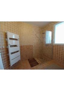 ein gefliestes Bad mit einer Dusche und einer Glastür in der Unterkunft Villa de Caractère in Pourcieux