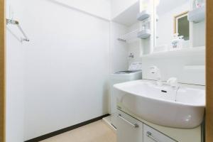 a white bathroom with a sink and a mirror at View Hakata 703 in Fukuoka