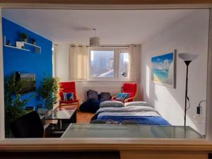 a living room with a bed and a couch at Comfy Nest near Angel and Old St in London