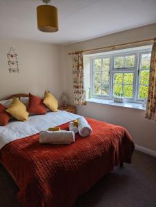 a bedroom with a bed with towels on it at Jasmine Cottage Lastingham North Yorkshire in Pickering