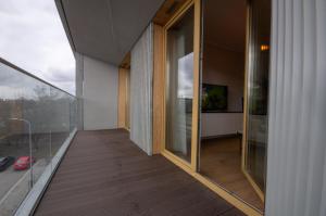 einen Balkon eines Hauses mit Glastüren in der Unterkunft InPoint Tauron Arena Apartment with Parking - Lema 17 in Krakau