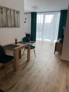 sala de estar con mesa, sillas y ventana grande en Rado apartments en Svit
