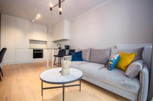 ein Wohnzimmer mit einem Sofa und einem Tisch in der Unterkunft InPoint Tauron Arena Apartment with Parking - Lema 17 in Krakau