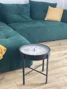 a clock on a table in front of a couch at Rado apartments in Jezersko