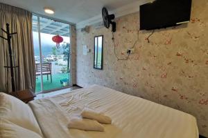 1 dormitorio con 1 cama con 2 toallas en OYO 89969 Mount Hill Villa Kundasang, en Ranau