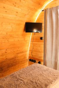 a bedroom with a tv on a wooden wall at Óbidos Wood Villas in Olho Marinho