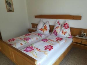 a bedroom with two beds with floral pillows at Haus Meissnitzer in Radstadt