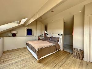 ein Schlafzimmer mit einem großen Bett im Dachgeschoss in der Unterkunft La Pelletière in Garches