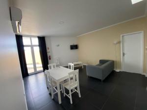 a living room with a table and chairs and a couch at White Pico Lodge in São Roque do Pico