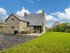 uma casa de pedra com um relvado verde em frente em 3 Bed in Brecon 93680 em Llandefalle