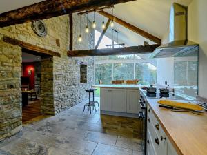 uma cozinha com uma parede de pedra e um balcão em 3 Bed in Brecon 93680 em Llandefalle