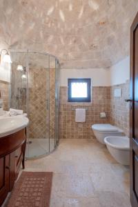 a bathroom with a shower and a sink and a toilet at Trulli Oasi Fiorita - Exclusive Apulian Holidays in Castellana Grotte