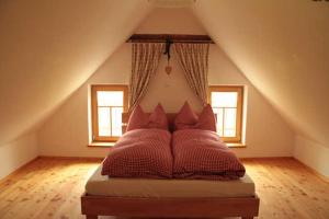 a bed with red pillows in a attic at Kellerstöckl 
