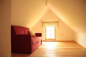 Kellerstöckl : غرفة معيشة مع أريكة حمراء ونافذة