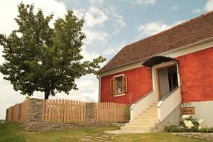 a red and white house with a tree and a fence at Kellerstöckl 