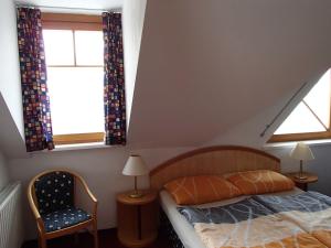 ein Schlafzimmer mit einem Bett und zwei Fenstern in der Unterkunft Ferienhaus Lutzmannsburg in Lutzmannsburg