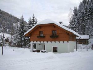 une grande maison en bois avec de la neige sur le toit dans l'établissement Oberbach, à Göstling