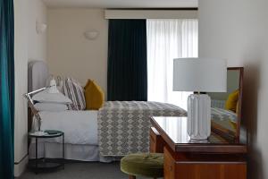 1 dormitorio con cama con espejo y mesa en Chestnut Villa, en Grasmere