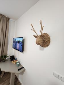 Una habitación con un escritorio y un televisor en la pared. en Landhaus Appartement, en Bad Salzuflen 6 fotos más
