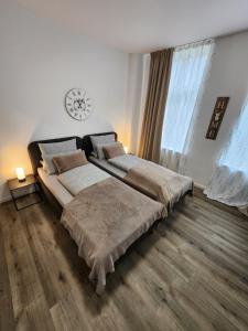 a bedroom with two beds and a clock on the wall at Landhaus Appartement in Bad Salzuflen