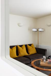 a living room with a black couch with yellow pillows at Chestnut Villa in Grasmere