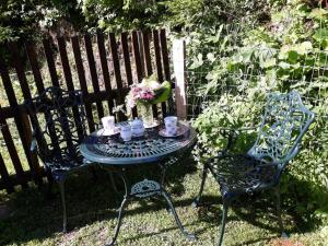 una mesa y dos sillas con tazas y flores. en Umundum Hütte, en Katsch Oberdorf