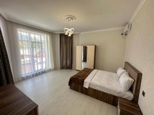 a bedroom with a bed and a large window at VIP Family Villa HOT POOL in Gabala