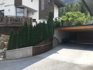 a house with evergreen trees in front of a driveway at Ferienhaus Piburg in Oetz