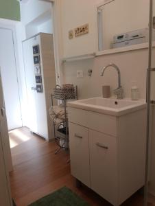 a white kitchen with a sink and a mirror at Stanza indipendente a Gallarate in Gallarate