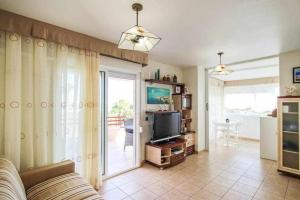 een woonkamer met een bank en een televisie bij Vistamar apartamento in Orihuela-Costa