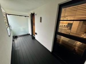 an empty hallway with a door and a window at Bournecoast - Brand New Clifftop Apartment with Balcony - FM9574 in Bournemouth