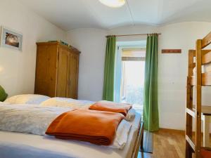 una camera con due letti con tende verdi e una finestra di Ferienhaus Baumgarten1 a Gnas